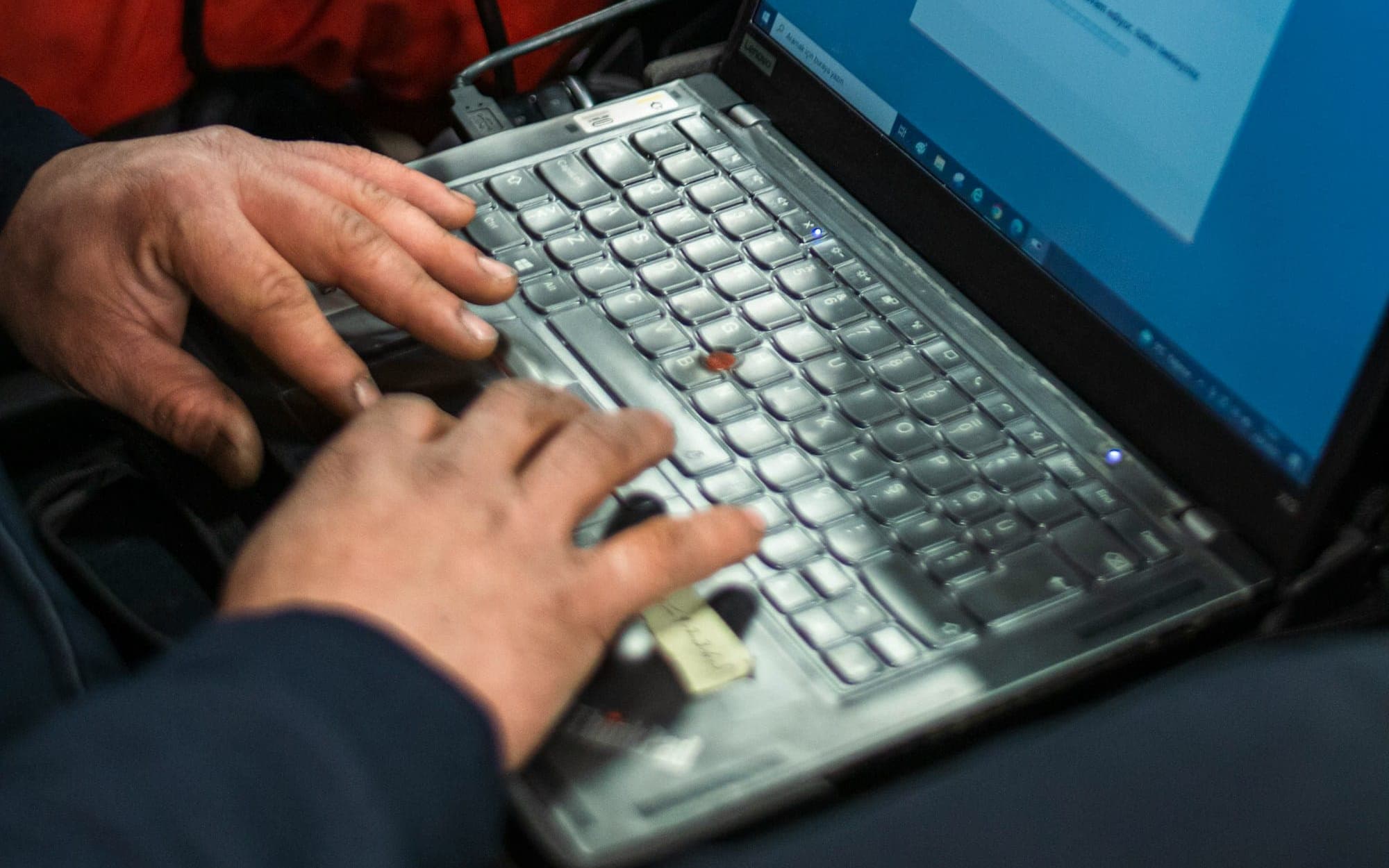 Un mecánico hace la diagnosis electrónica de un coche con un portátil.