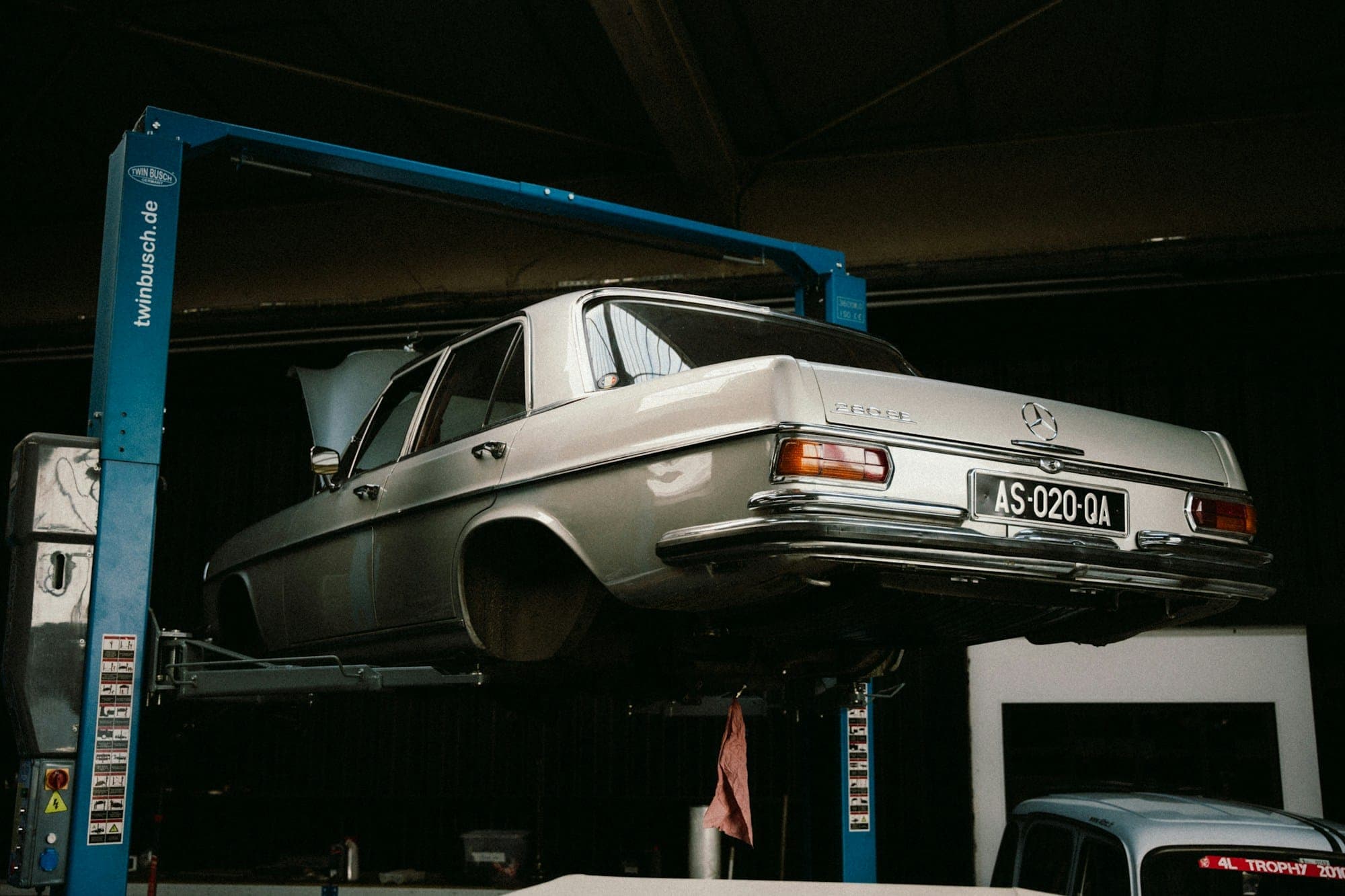 Un coche en el elevador del taller, con la suspensión a la vista.